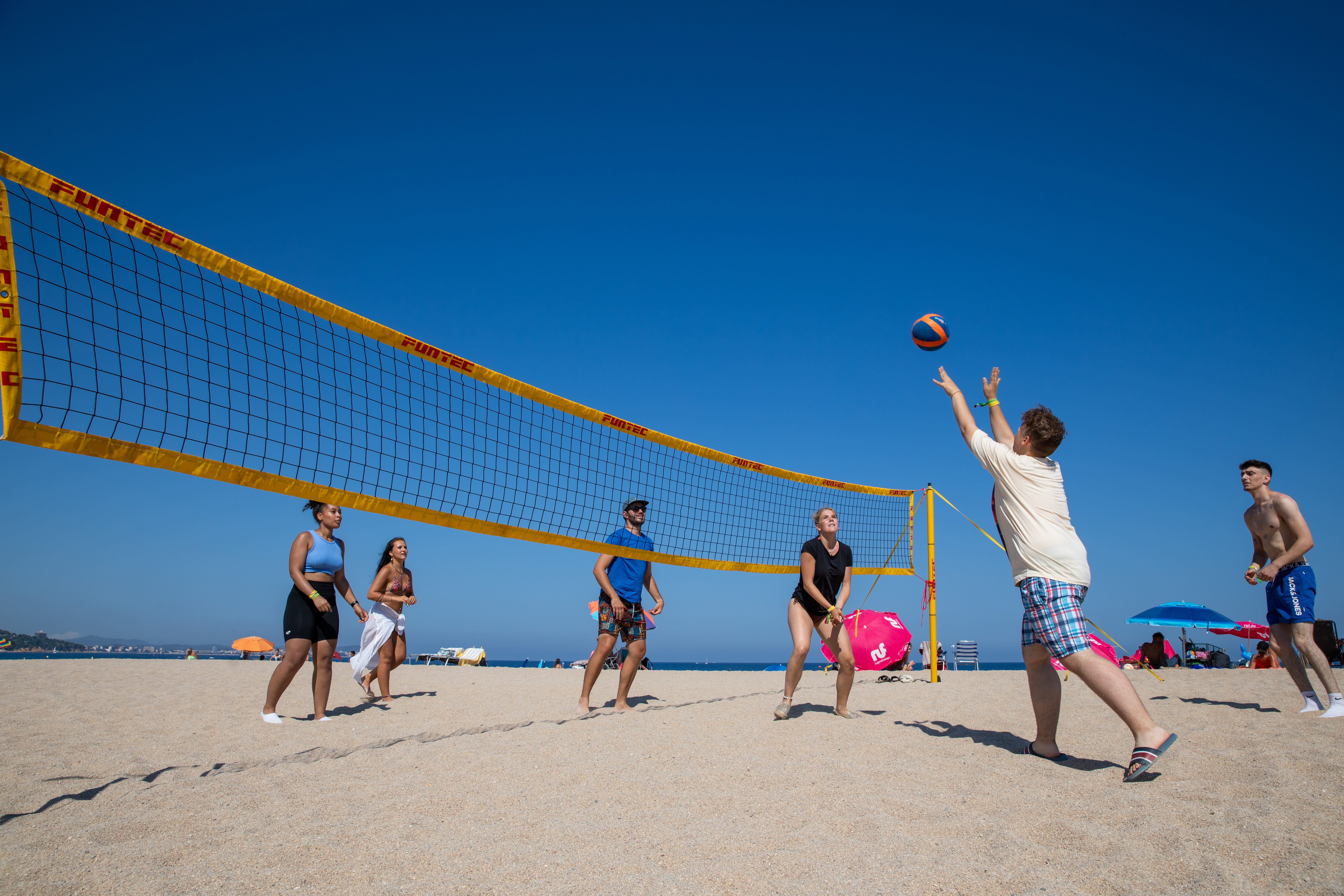 Gäste spielen Volleyball am Strand 